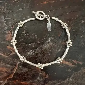 Delicate floral theme and faceted sterling silver beads sparkle in this nature inspired design